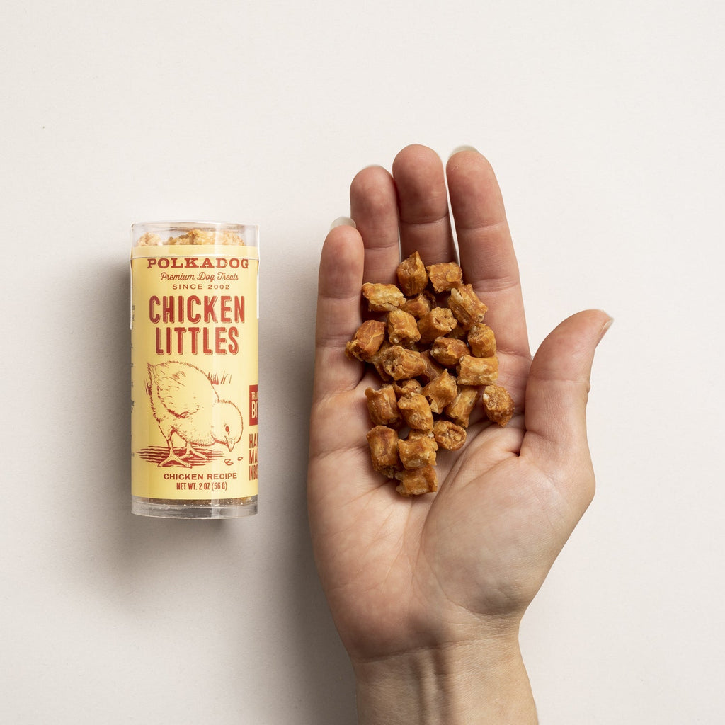 A hand holding loose Polkadog Chicken Littles dog treats