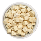 A white bowl filled with small, pale yellow cubes of Weruva Paw Lickin' Chicken Freeze Dried cat food, viewed from above on a white background.