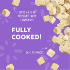 Scattered on a purple background: Weruva Paw Lickin' Chicken Freeze Dried—fully cooked chicken breast cat food you can serve as is or rehydrate, safe and ready to handle.