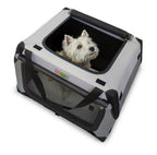 Small white dog comfortably sitting inside a DogGoods foldable crate, peeking out from the top opening. The crate features mesh ventilation, sturdy handles, and a soft fleece mat.