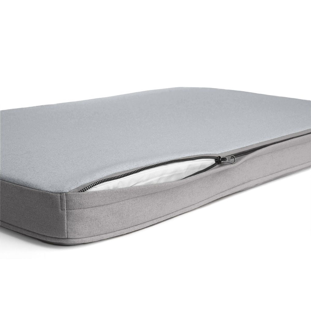 A grey (light grey) Diggs snooz pad with an open zipper.