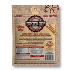 Back of a bag of Butcher Shop Natural Dog Chews, showing product details, ingredients, feeding guidelines, and a small image of two dog chews on a tan background.