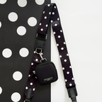 Cocopup London black bag and small treat pouch on a black and white polka dot surface.