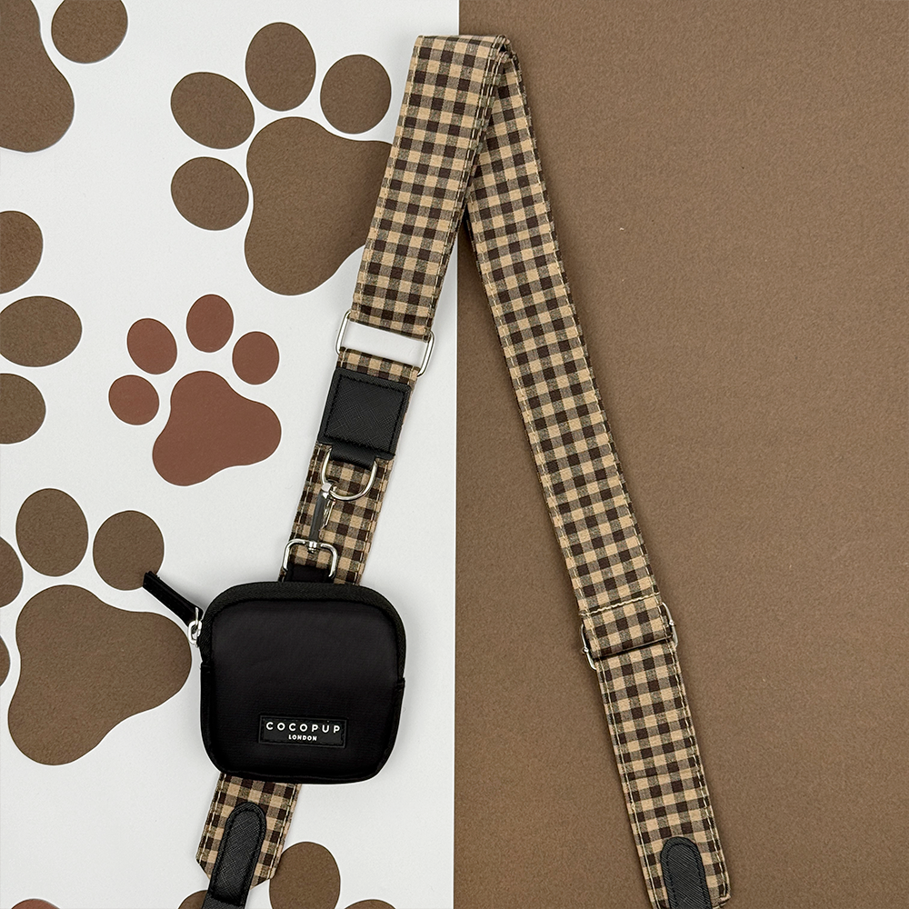 Black Cocopup London dog walking bag with a plaid strap, designed for carrying treats or dispensing poop bags.