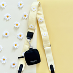Black dog walking bag with a cream daisy-patterned strap, matching treat pouch, and attached poop bag dispenser.