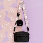 Black Cocopup London dog walking bag with pink strap featuring dinosaur pattern.