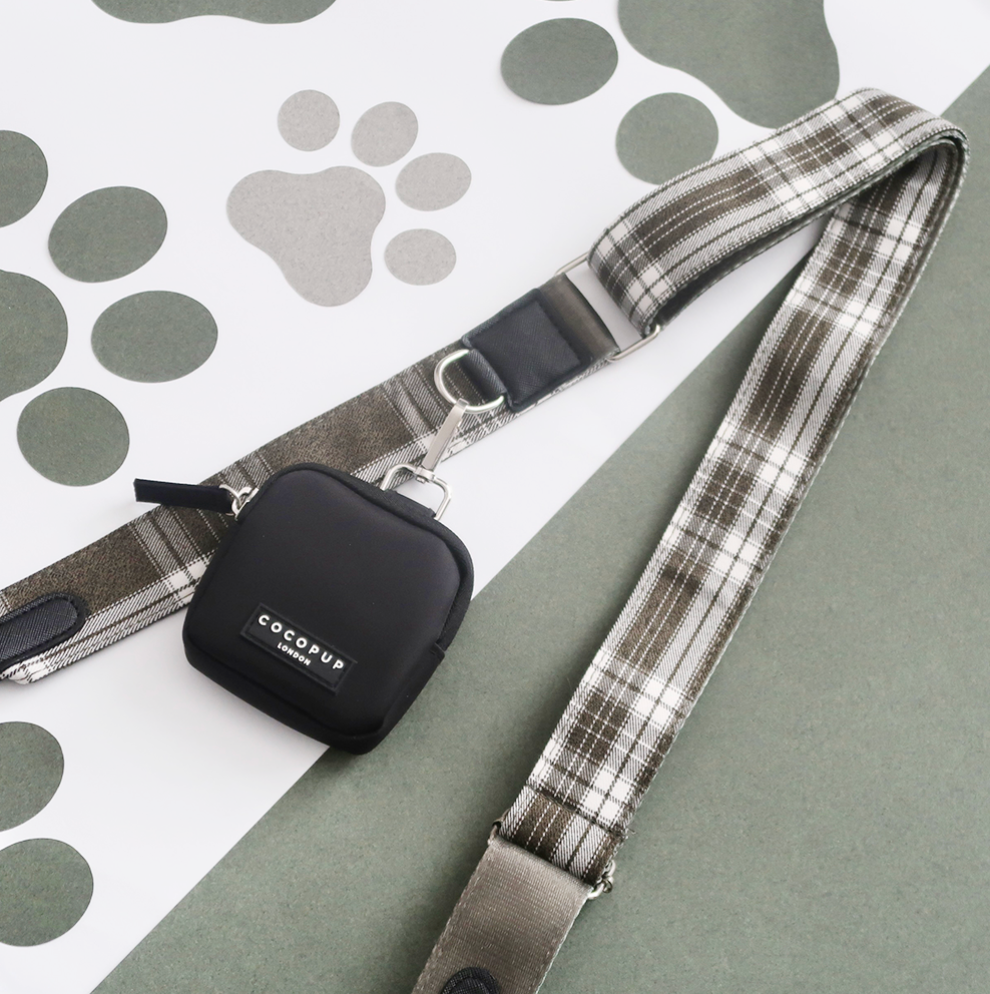 Plaid dog leash and treat pouch featuring black paw prints on fabric, shown together on a neutral background.