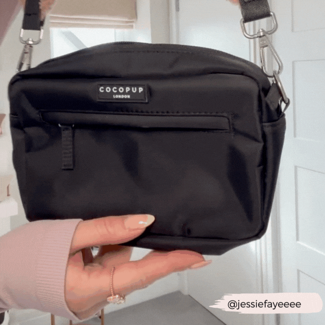 Black Cocopup London dog walking bag with a black and white checkered strap held in one hand.