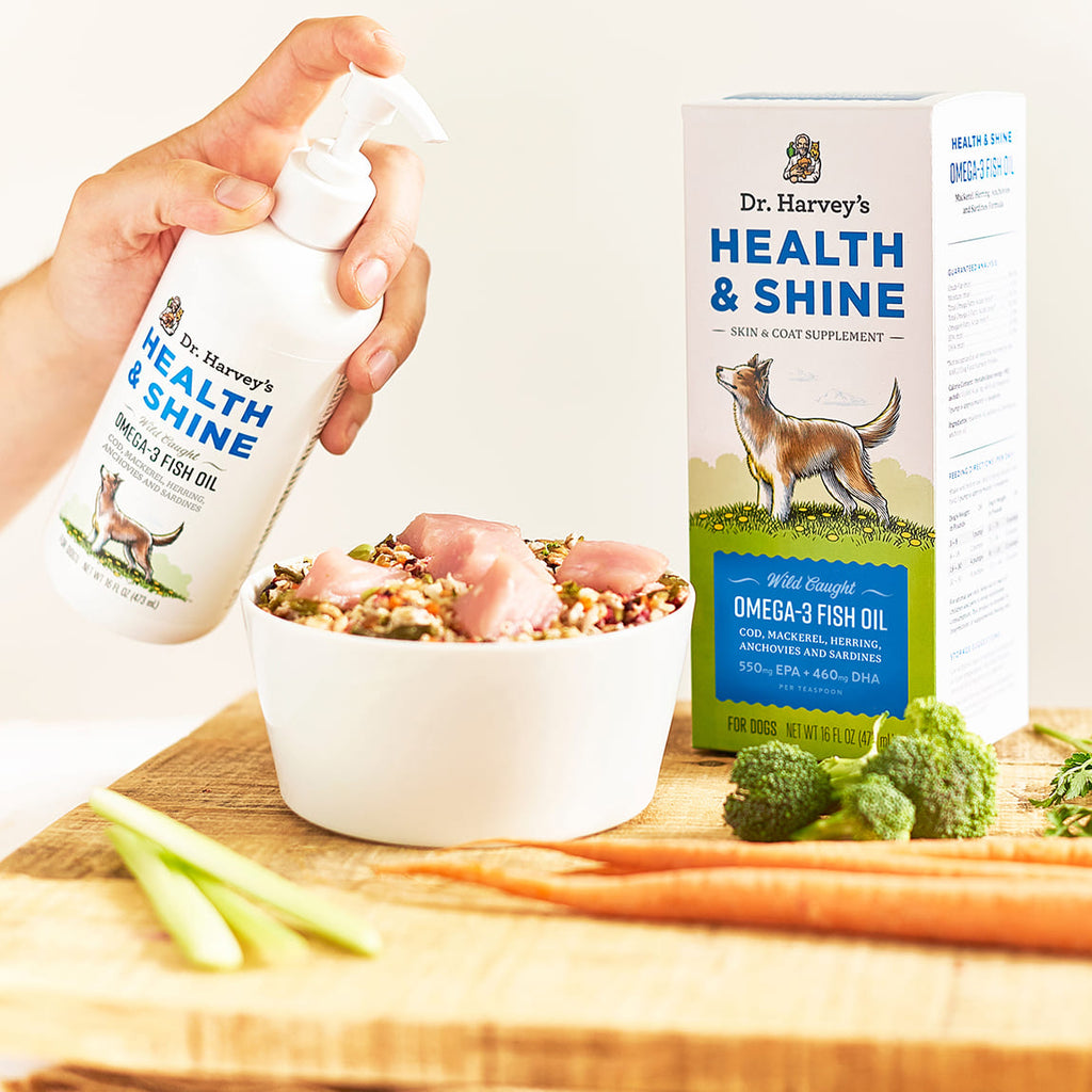 Dr. Harvey's Health & Shine Omega-3 Fish Oil pump bottle being added to a bowl of raw dog food