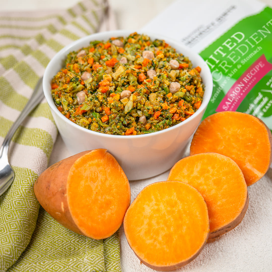 Bowl of chopped vegetables with sweet potato slices and Nature's Recipe Limited Ingredient Salmon Recipe dog food bag