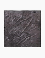 The Geometry Sweet Treats is a square microfiber dog towel in black and gray with a subtle abstract design and a small black label in one corner. Made from absorbent recycled materials, the towel is shown flat on a white background.