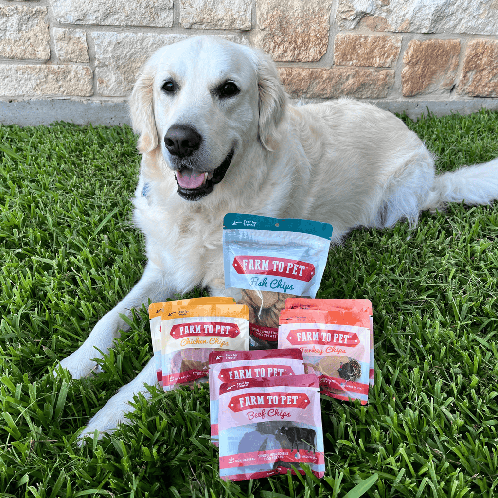 A white dog laying on grass with 'Farm to Pet' pet food packages.