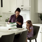 Woman and child in a kitchen setting up the mesh butterfly habitat.