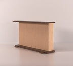 A Cat-e-Corner table placed next to a sofa, integrating a cat's scratching post with a small table, in a room with a plant and a colorful cushion.