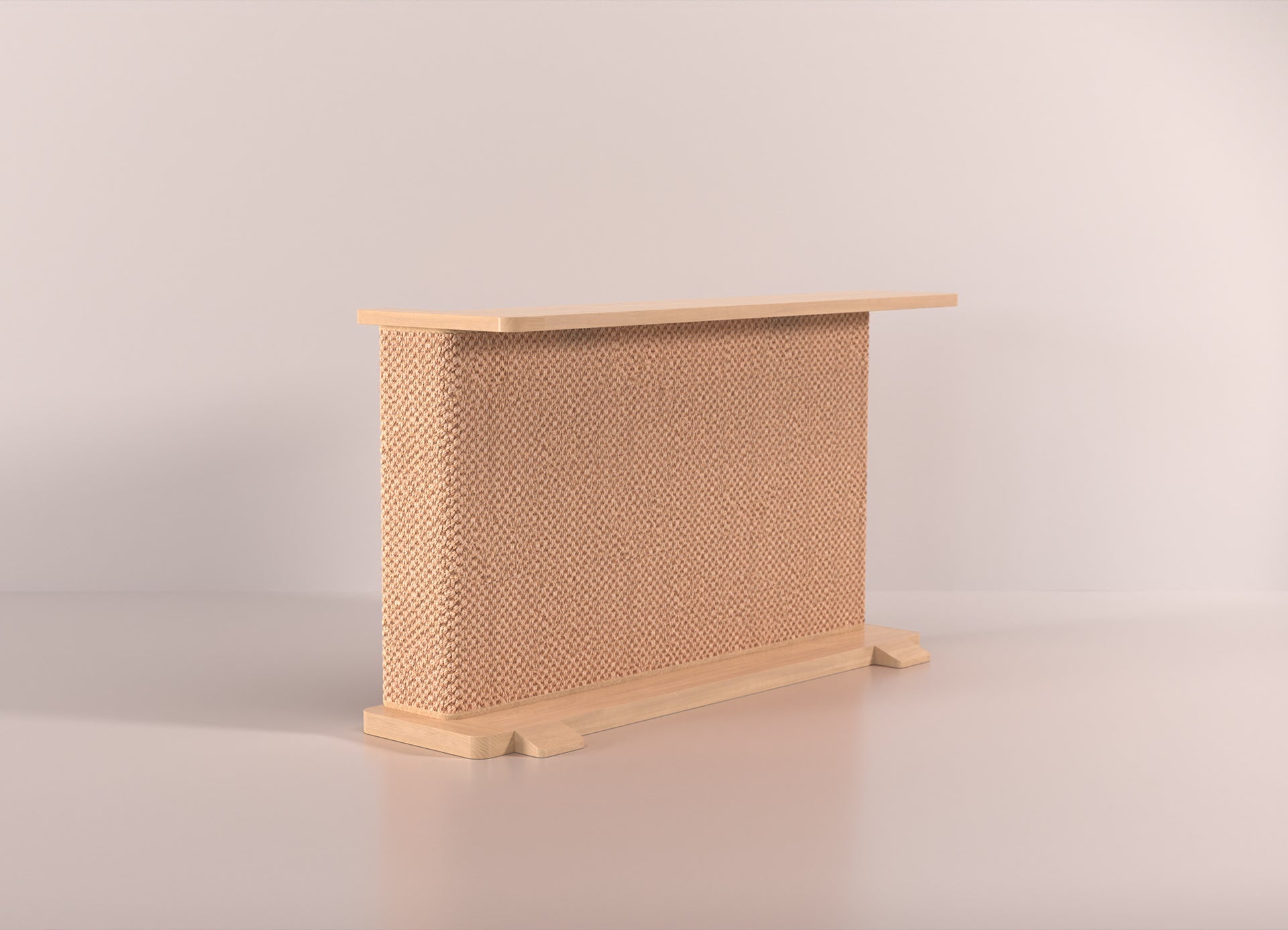 A Cat-e-Corner table placed next to a sofa, integrating a cat's scratching post with a small table, in a room with a plant and a colorful cushion.
