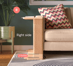A Cat-e-Corner table placed next to a sofa, integrating a cat's scratching post with a small table, in a room with a plant and a colorful cushion.