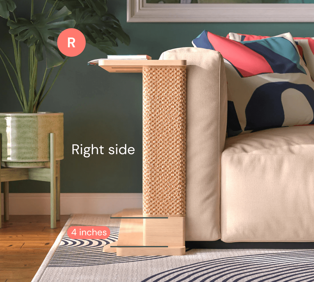 A Cat-e-Corner table placed next to a sofa, integrating a cat's scratching post with a small table, in a room with a plant and a colorful cushion.