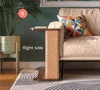 A Cat-e-Corner table placed next to a sofa, integrating a cat's scratching post with a small table, in a room with a plant and a colorful cushion.