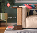 A Cat-e-Corner table placed next to a sofa, integrating a cat's scratching post with a small table, in a room with a plant and a colorful cushion.