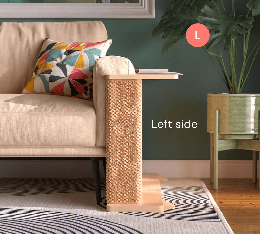 A Cat-e-Corner table placed next to a sofa, integrating a cat's scratching post with a small table, in a room with a plant and a colorful cushion.