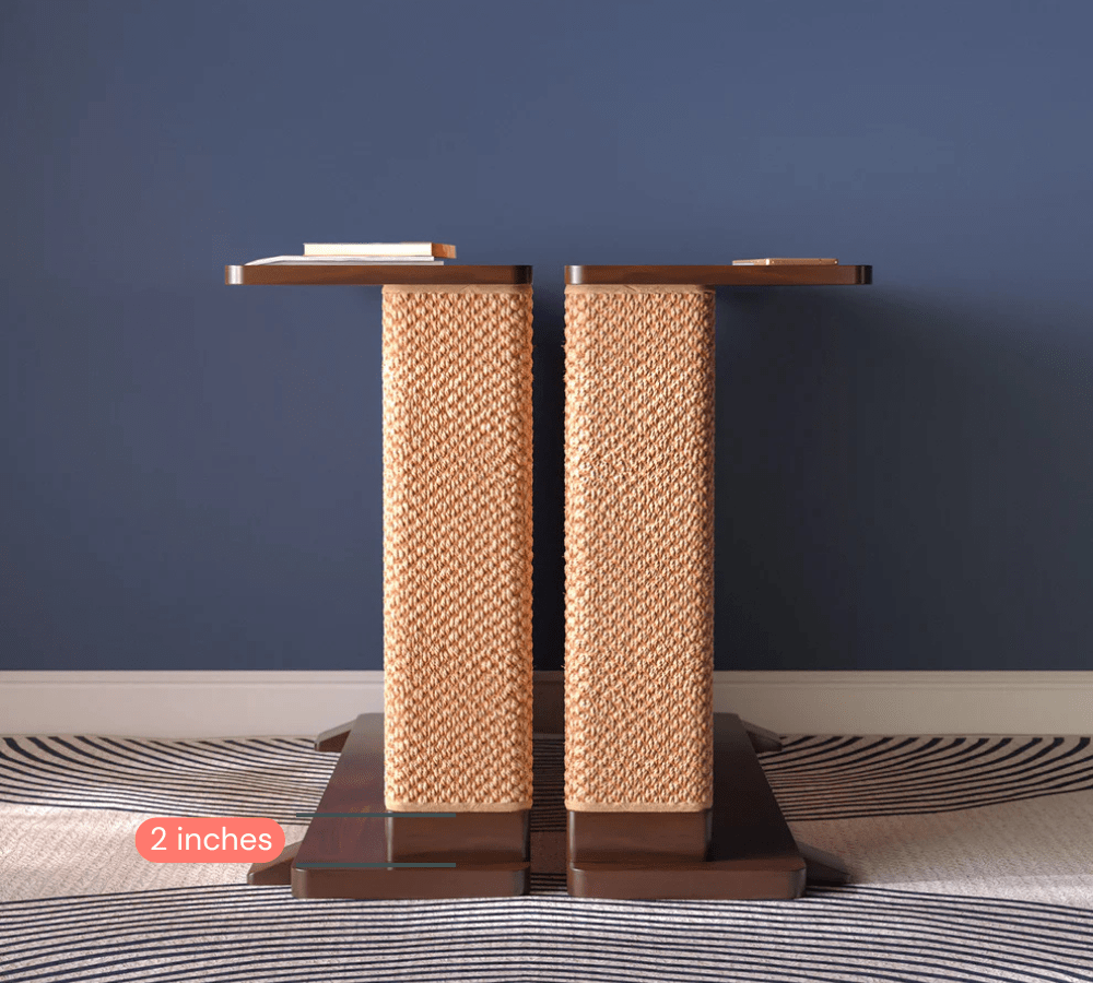 A Cat-e-Corner table placed next to a sofa, integrating a cat's scratching post with a small table, in a room with a plant and a colorful cushion.