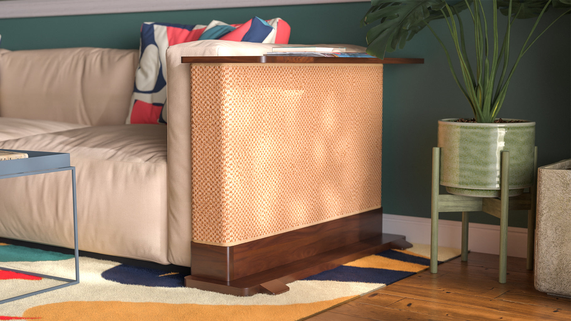 A Cat-e-Corner table placed next to a sofa, integrating a cat's scratching post with a small table, in a room with a plant and a colorful cushion.