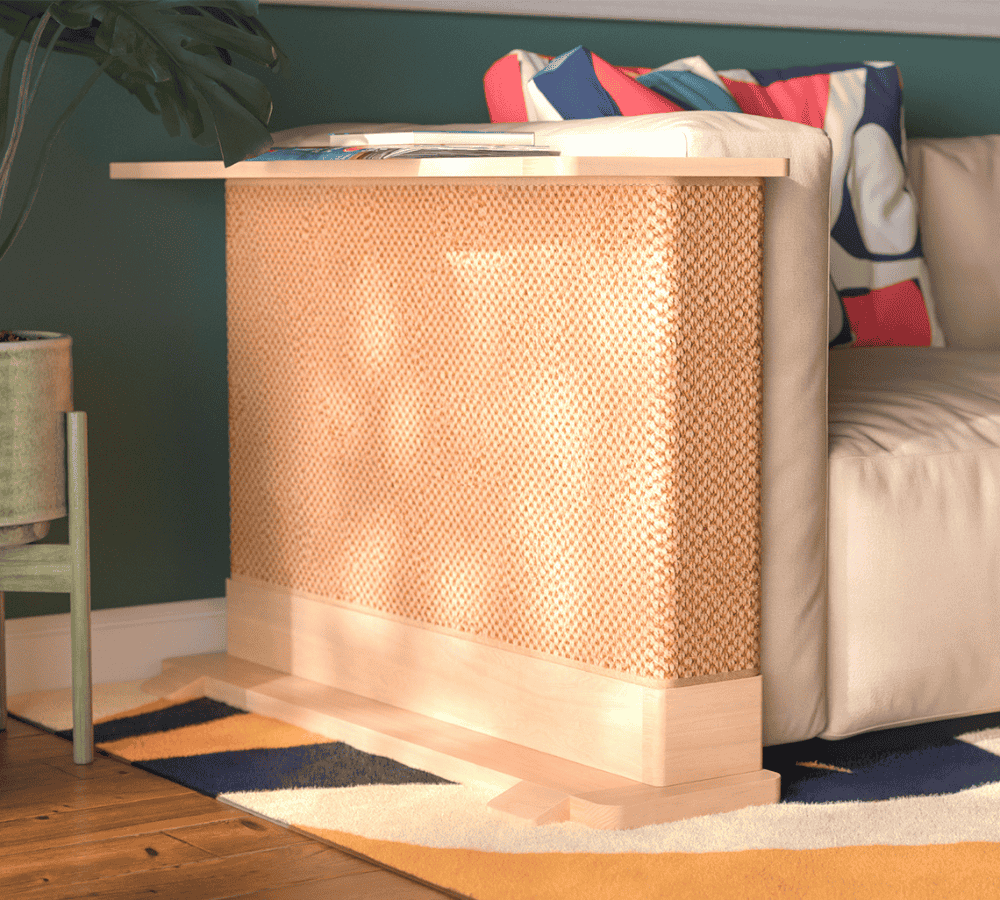 A Cat-e-Corner table placed next to a sofa, integrating a cat's scratching post with a small table, in a room with a plant and a colorful cushion.