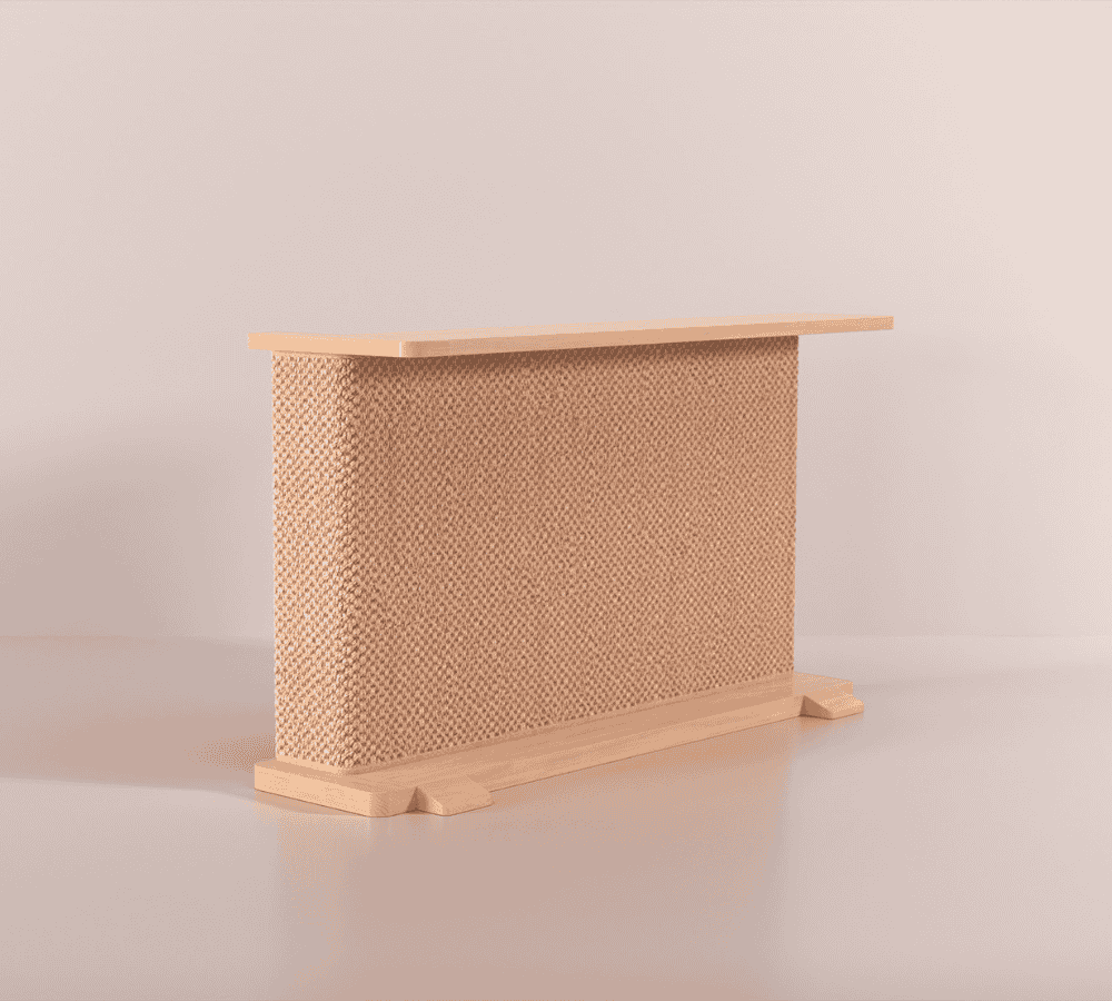 A Cat-e-Corner table placed next to a sofa, integrating a cat's scratching post with a small table, in a room with a plant and a colorful cushion.