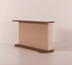A Cat-e-Corner table placed next to a sofa, integrating a cat's scratching post with a small table, in a room with a plant and a colorful cushion.