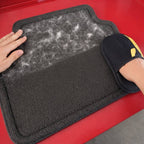 Using the PurePath™ glove to scrape deeply embedded dog hair from a black car floor mat