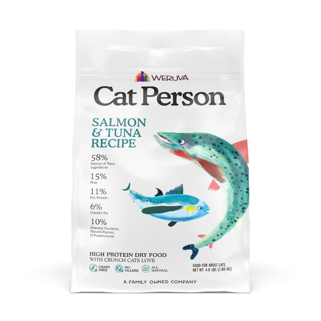 A white bag of Cat Person Salmon & Tuna Dry Food displays salmon and tuna illustrations, ingredient percentages, nutritional benefits, and a grain-free formula on the label.
