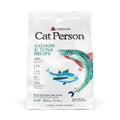 A white bag of Cat Person Salmon & Tuna Dry Food displays salmon and tuna illustrations, ingredient percentages, nutritional benefits, and a grain-free formula on the label.