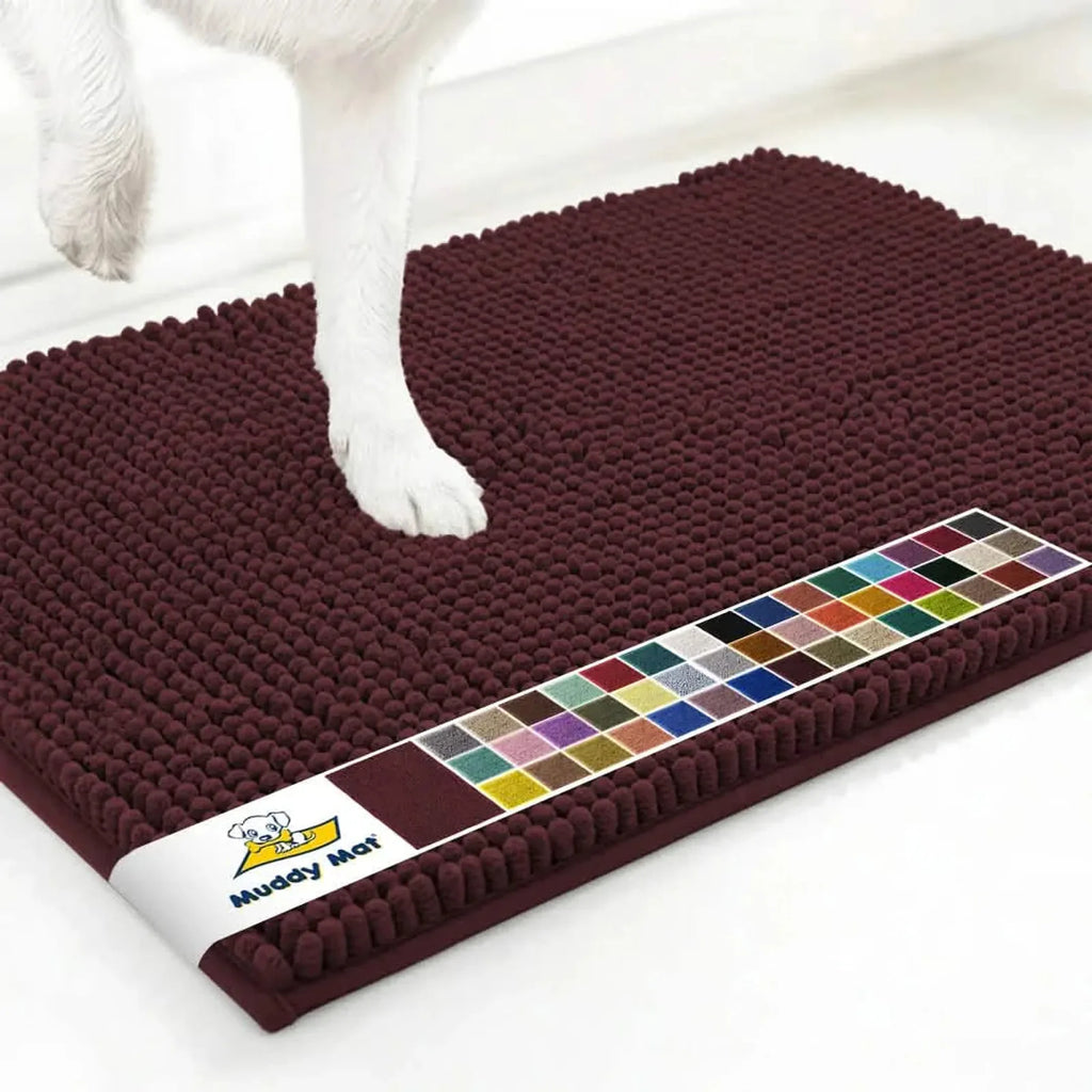 Angled close up of Muddy Mat anti-mud dog door mat in rust showing textured chenille surface and dog paw on white floor