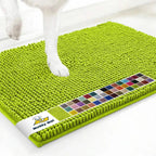 Close-up of Muddy Mat® anti-mud dog door mat in spring green showing chenille nubs and a dog’s paw on a white floor