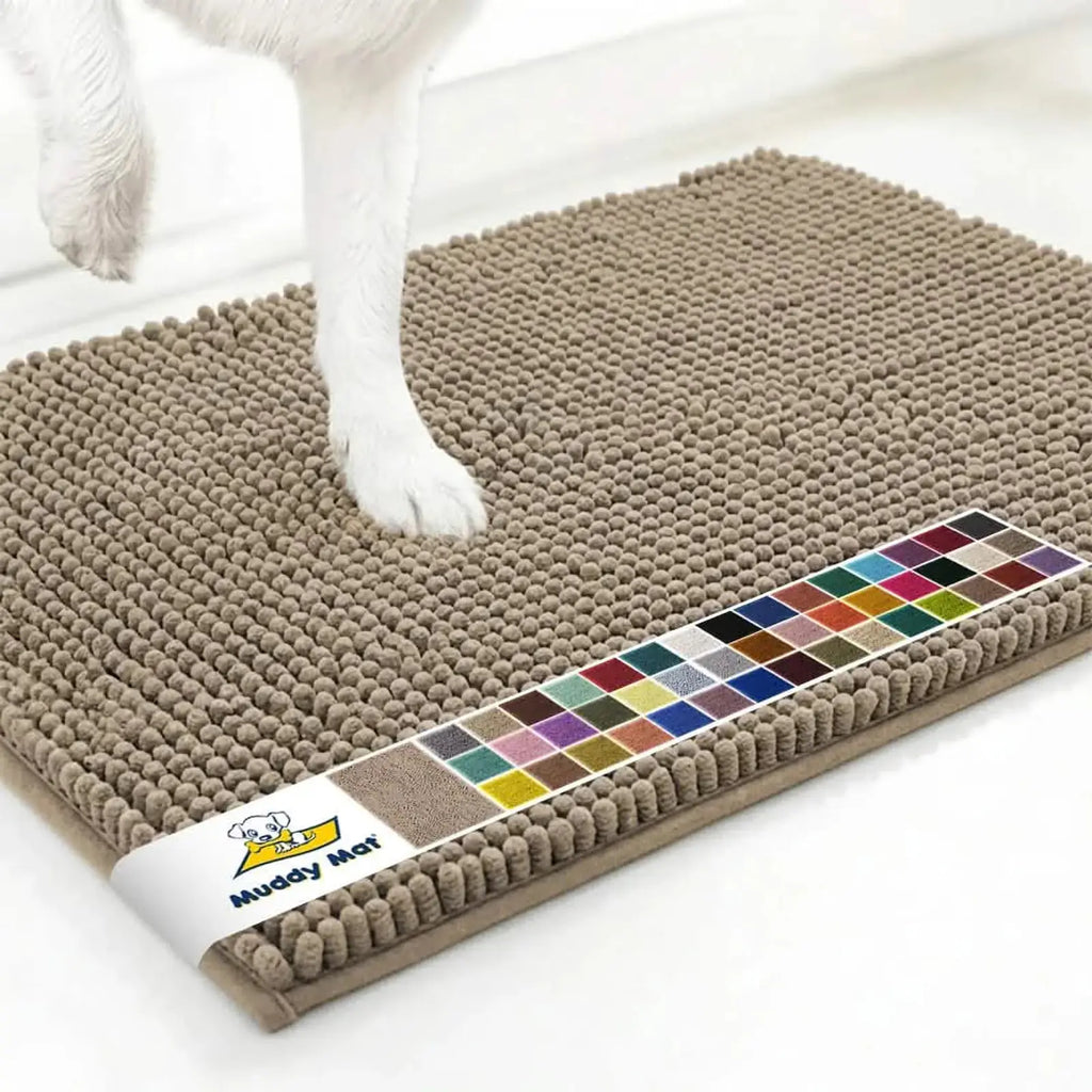 Close up of Muddy Mat anti mud dog door mat in taupe showing textured chenille surface, color swatch band and a dog’s paw on a white floor