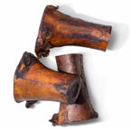 Angled view of three smoked beef marrow bones showcasing exposed marrow and smoked finish on white background