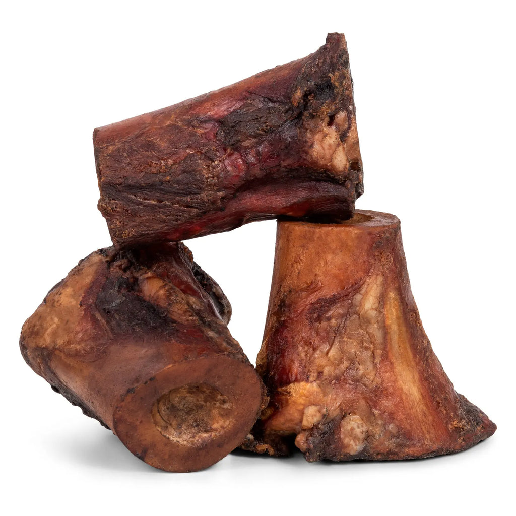 Close-up of smoked beef marrow bone showcasing smoked, textured marrow on white background