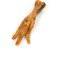 Angled view of Hanna’s smoked chicken foot showing three toes and wrinkled dried skin on white background